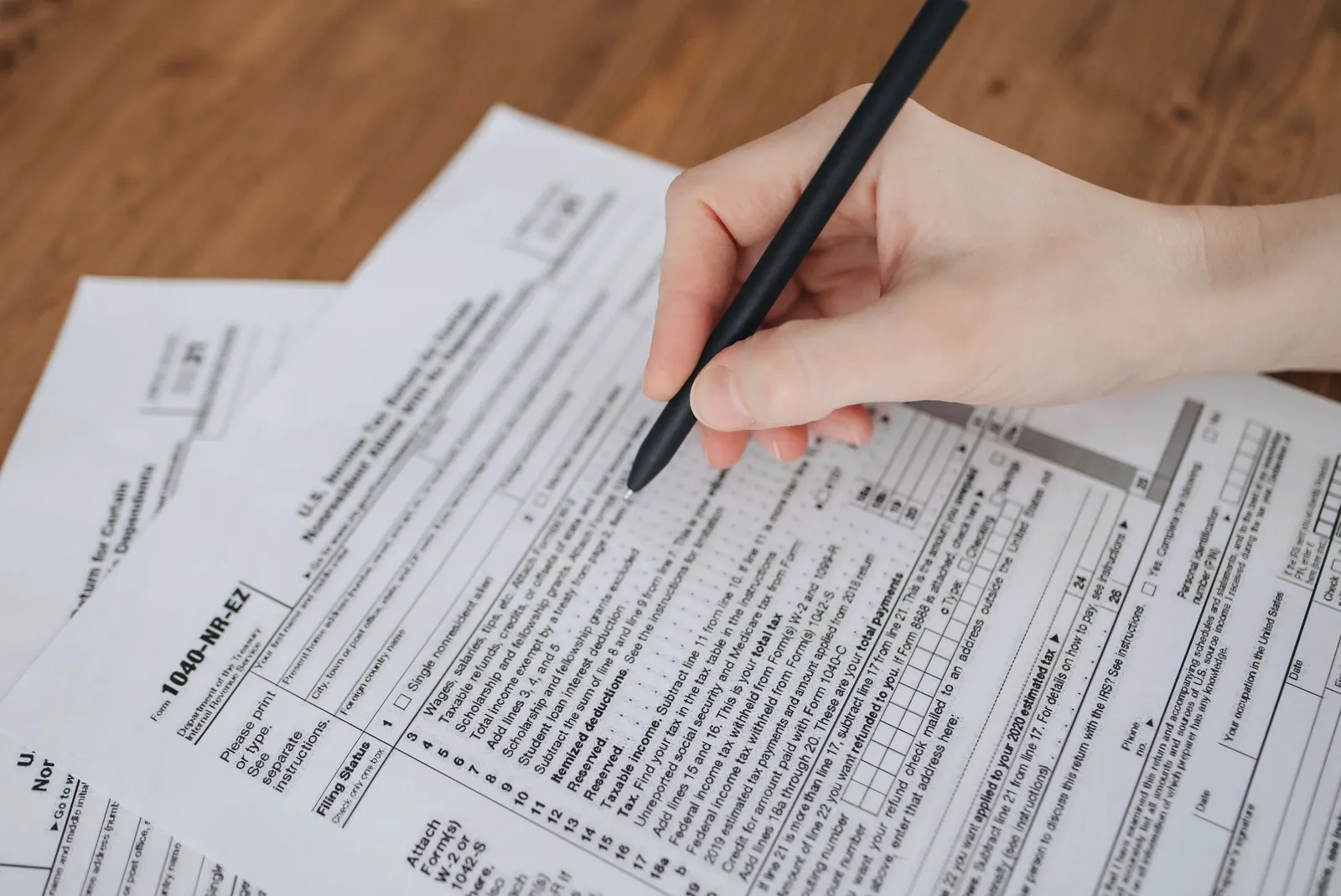 Salariés réunis autour d'un bulletin de paie, calculant une prime de participation avec une calculatrice